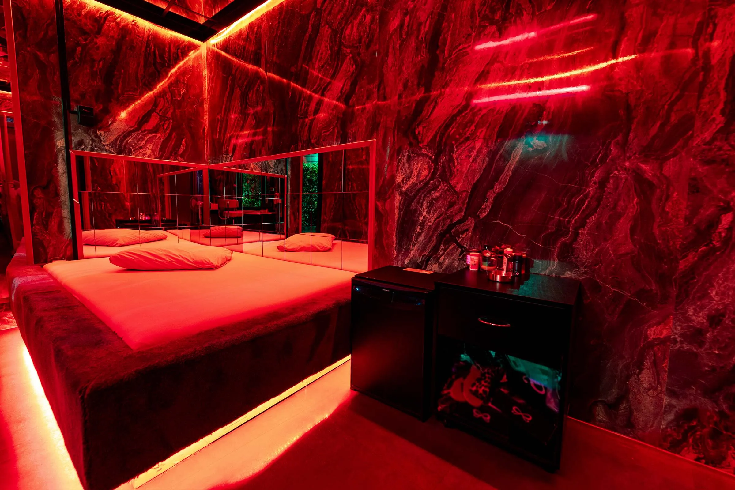 Een opgemaakte kamer in rood licht.